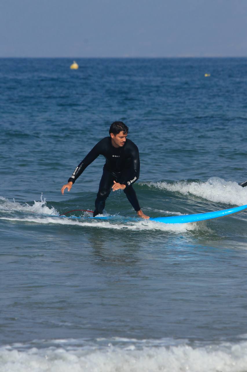 Surfeur débutant en équilibre sur une planche bleue