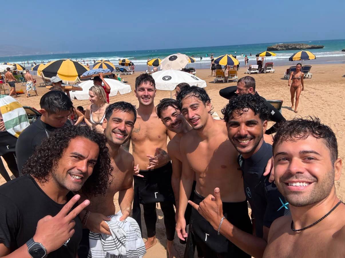 Groupe de surfeurs souriants sur la plage après une session