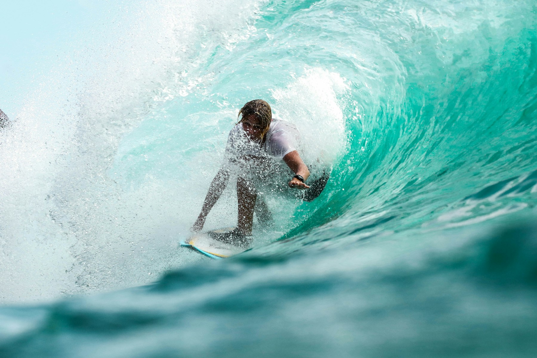 Surfeur dans une vague turquoise